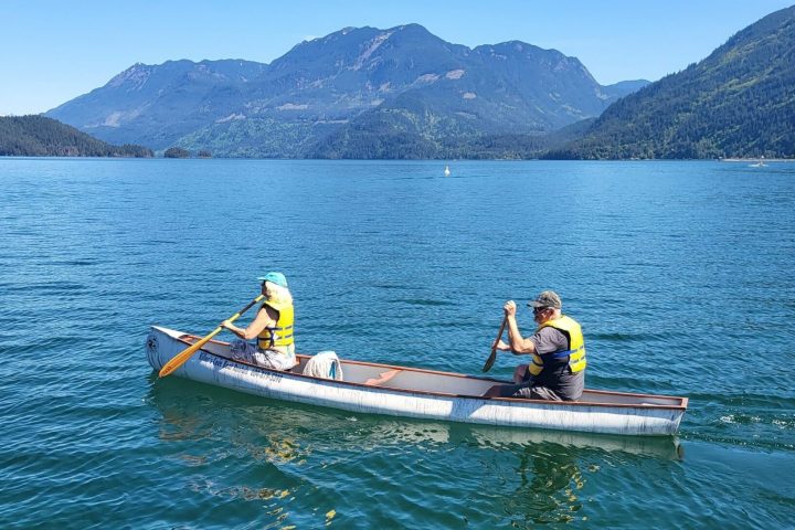 an older couple in a canoe on a body of water